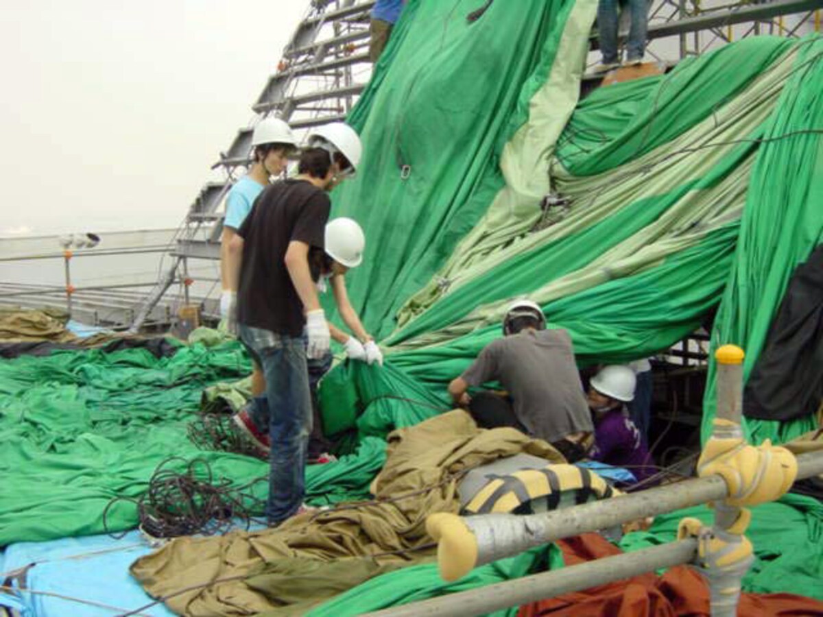 スライダーにはさまったバルーンの生地を引っ張る学生ボランティアたち（2001年9月19日撮影）