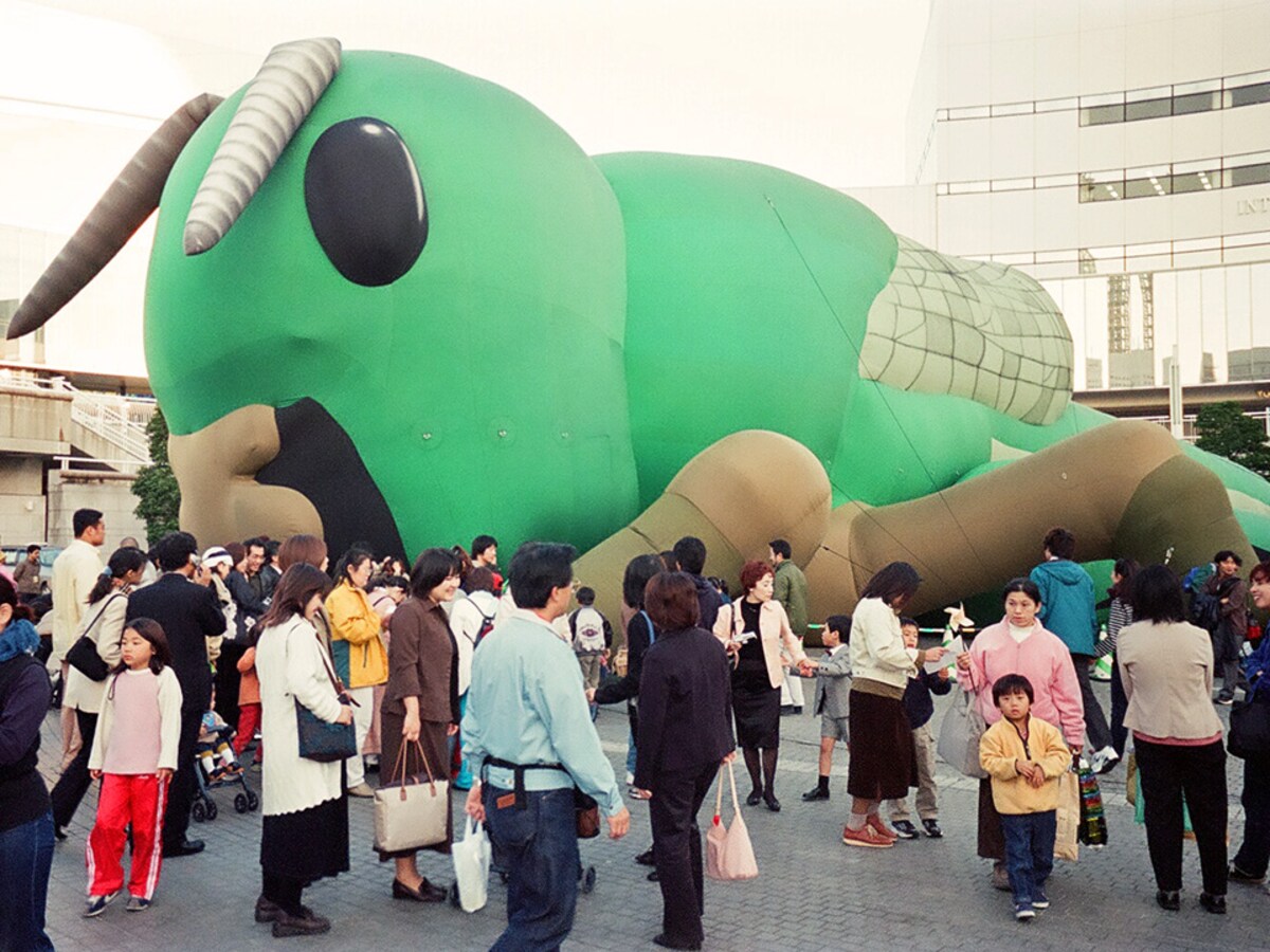 横浜トリエンナーレ最終日2001年11月11日。地上置きされたバッタにたくさんの人が集まった。71日間のトリエンナーレ期間中、バッタが空中に上がったのは23日だった（2001年11月11日撮影）