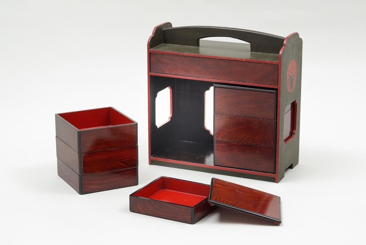 A typical lacquered wooden bento box from the Azuchi-Momoyama period (ca. 16th century). The box shows a total of 6 small compartments for various types of food. This particular bento set also has a main compartment larger than the others. The box has a handle on top.