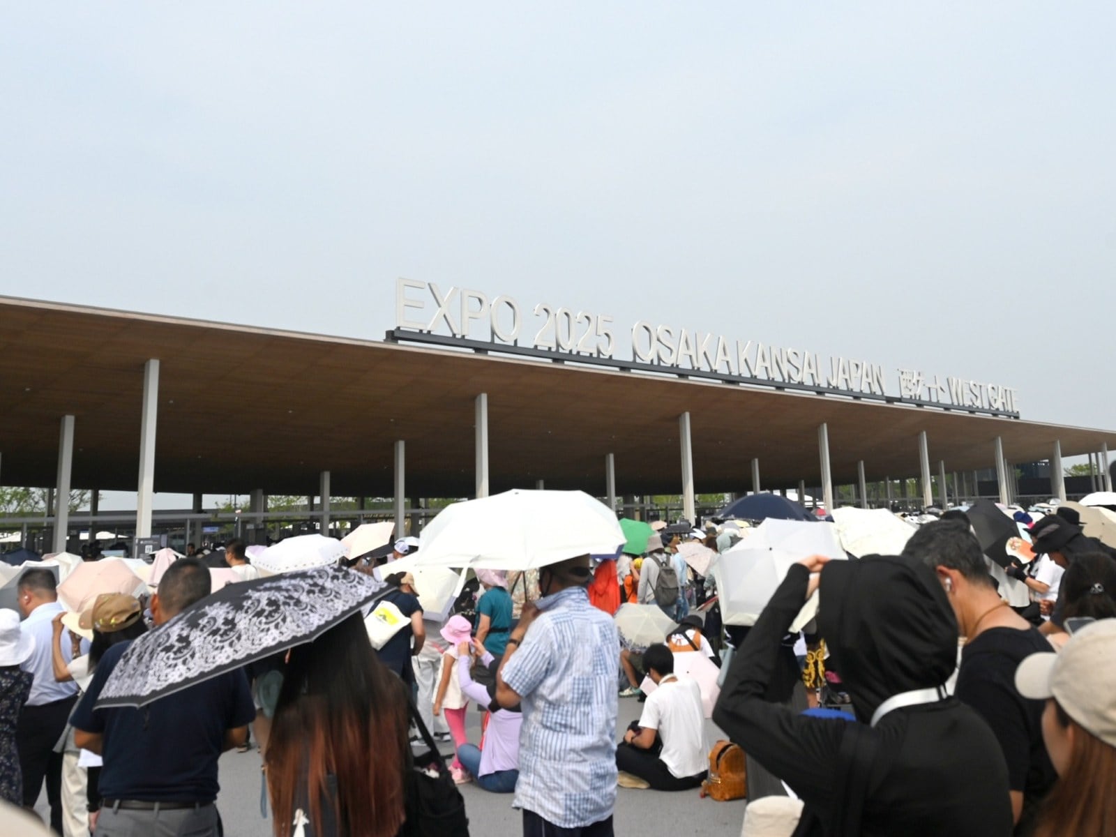 万博の西ゲート、朝8時半ごろ。暑さで日傘をさして待つ人も多い