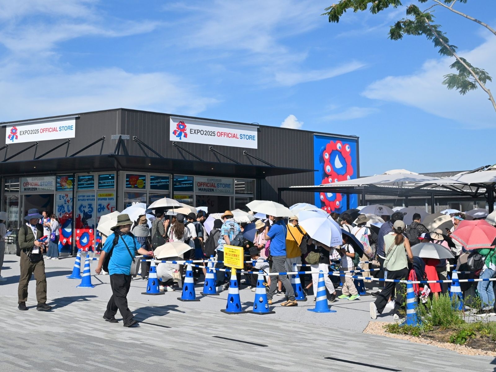 ★「ミャクミャクくじ」の店舗（左）と入場待ちの列。この時は約2時間待ち