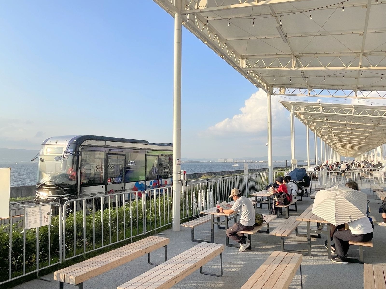 「団体休憩所 西」にはテーブルやベンチがある。奥に「e Mover」も走る