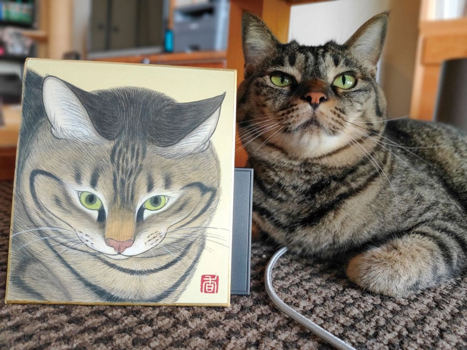 色紙作品「まなざし」（136×120mm）と並ぶコイモちゃん　※画像出典：『コイモ 小熊香奈子画集』（辰巳出版）