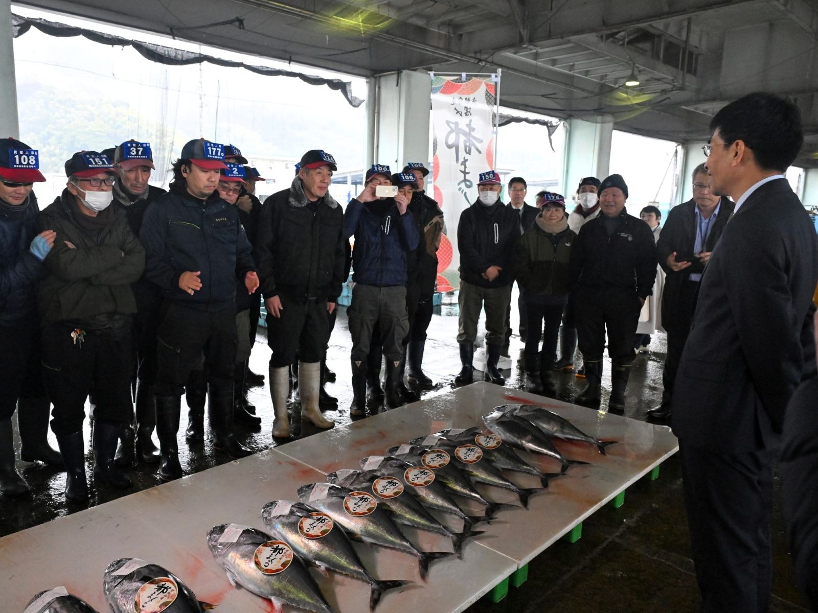 「都まぐろ」初競りの様子。右は京都府の武田一寧副知事（2026年2月11日、京都府舞鶴市）