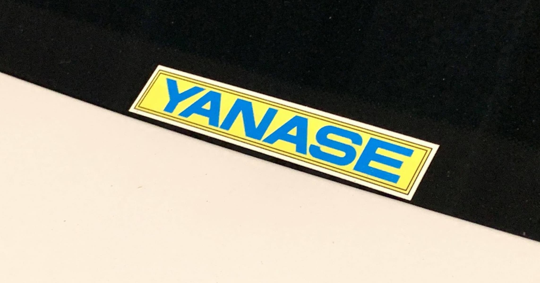 国産車ディーラーのステッカーが年々小さくなるなか、「YANASE」ステッカーが色もサイズも変えない理由