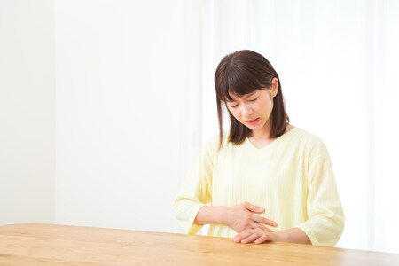 胃の痛みを感じる女性