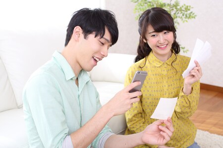 レシートを見て笑顔になる男女