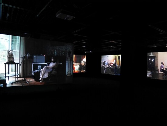 ラグナル・キャルタンソン《ザ・ビジターズ》2012……ビデオ9面、64分の映像作品。ヘッドフォンから聞こえる他者の演奏音を頼りに、異なる部屋で一つの曲を奏でようと試みるようすを9つのスクリーンに投影。孤独な作業から生まれるハーモニーをお楽しみあれ。ヨコハマトリエンナーレ2017展示風景（2017年8月3日撮影）