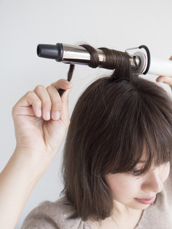 毛先はつまんだまま、アイロンにぐるぐると巻きつける