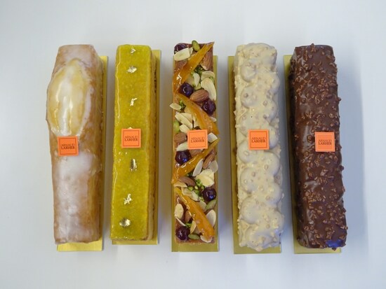 「アルノー・ラエール 広尾本店」に並ぶケーク類。左から「ケーク シトロン」（税込1,900円）、「ケーク オランジュ」（税込2,500円）、「ケーク フリュイ」（税込2,500円）、「ケーク キャラメル」（税込2,800円）、「ケーク ジャンドゥージャ」（税込2,800円）