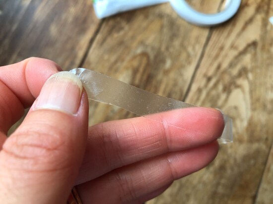 ダイソーの「手で切れる両面テープ　フィルム製」は薄く、透けてる