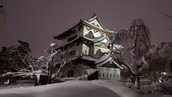 雪景色の弘前城天守閣のライトアップ