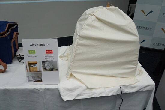 食事をハエなどの虫から守る「蠅帳（はいちょう）」にナノイーX発生器を入れて使う「スポット消臭カバー」。「開いた状態で中にナノイーX発生器を入れることで、下の空間を消臭できます。日常においては、子どもやペットがもどしてしまった時、応急処置的に拭き取った後に使うとか、なかなか洗えない布団やソファーなどの匂いを取るために使えます。ソールが汚れていて靴箱にしまいたくないスポーツシューズなどを、玄関の土間に置いたまま被せるという使い方を想定しています」（畔柳助教）
