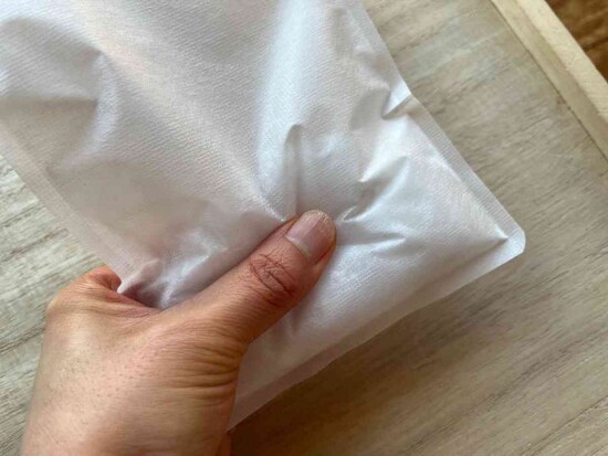 白い携帯用エチケット袋に水を入れても、カチカチにはならない