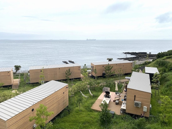 ひと部屋ひと部屋独立したグランピング施設が、​​​​​海辺に面したガーデンに並ぶ