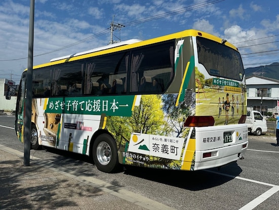 岡山駅から奈義エリアまではシャトルバスも運行（一日一往復、片道1800円）。バスの側面には「めざせ！子育て応援日本一」の文字が