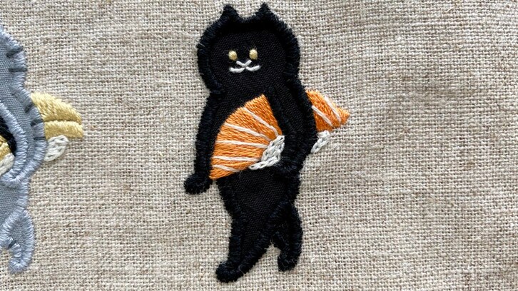 サーモンの握り寿司をかっこよく持ち運ぶ猫の刺繍に「こういうのめっちゃ好きです」「このしたり顔よw」と絶賛の声