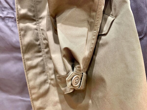 袖に付いたボタンを留めることで絞りを効かせたブロックテックコート。