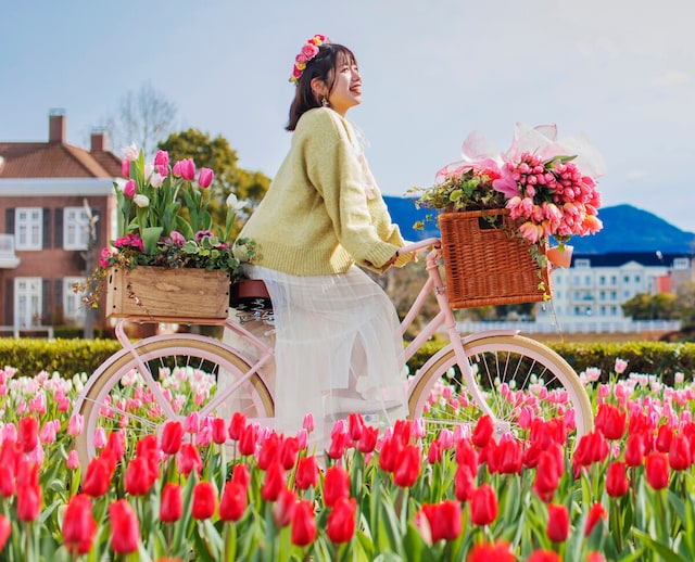 フラワーロードのオブジェ自転車に乗っている女性がかぶっているのが花の街の花かんむり　（c）ハウステンボス／J-21301