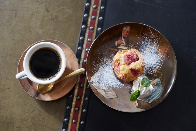 写真はポートマンズコーヒー（400円）と、SEASON’S マフィン（400円）。テーブルとして使われているのは古いトランクケースで、スイーツは絵皿で提供されます。