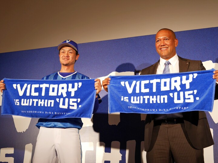 2018年シーズンスローガン「VICTORY is within US.」と入ったタオルを掲げる大和選手（左）とA・ラミレス監督（右）（2018年1月18日撮影）