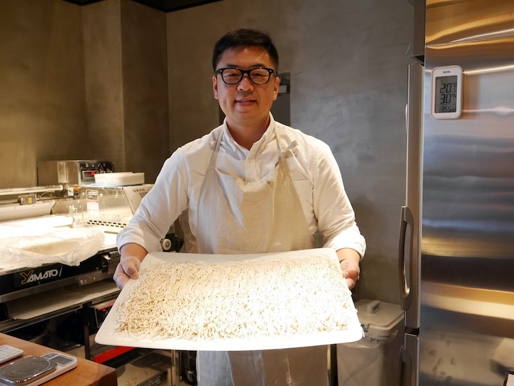 打ち立ての蕎麦を持つ、店主の宮崎憲吾さん（2018年2月28日撮影）