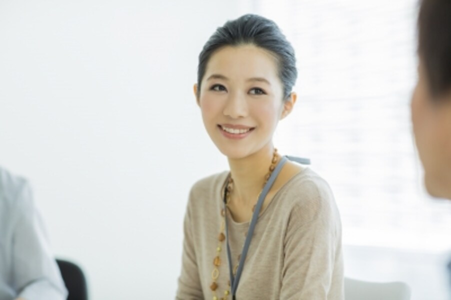 笑顔で会話をする髪をアップしている女性