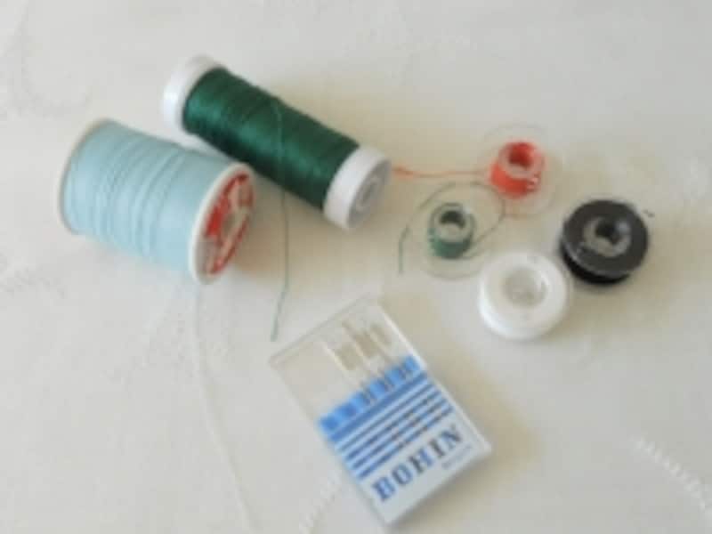  画像左よりミシン糸、ミシン針、ボビン。針と糸は、布に合った最適な物を選んでください