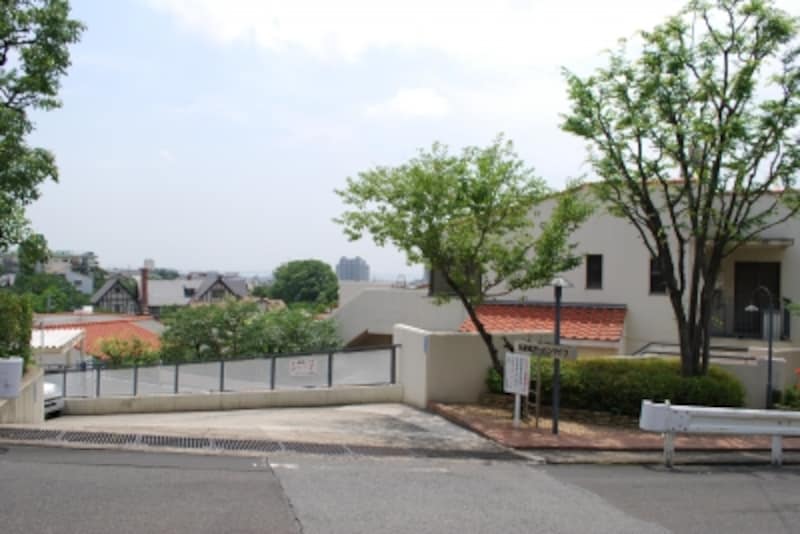 斜面地に建つ分譲マンション。オレンジ色の屋根が眼下に見える。