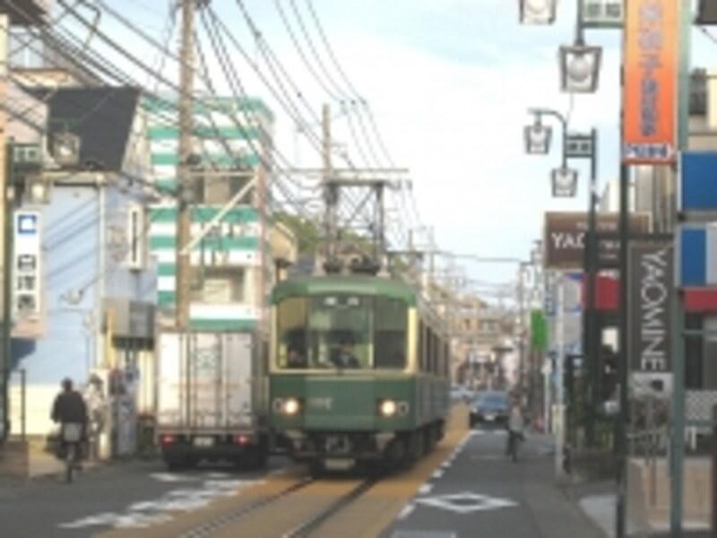 通りの真ん中を走る江ノ電。車はその左右を走り、歩行者は一番外側。左右には古い建物も多かった