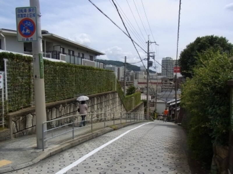 駅へと向かう坂道から駅のある（東側）方面をみる。かなりの高低差がわかる。