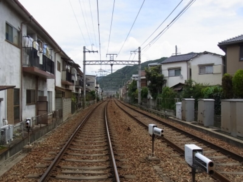 駅北東方向へは「川西能勢口」駅を始発とする能勢電鉄が走る。線路際までびっしりと戸建が並ぶのがわかる。