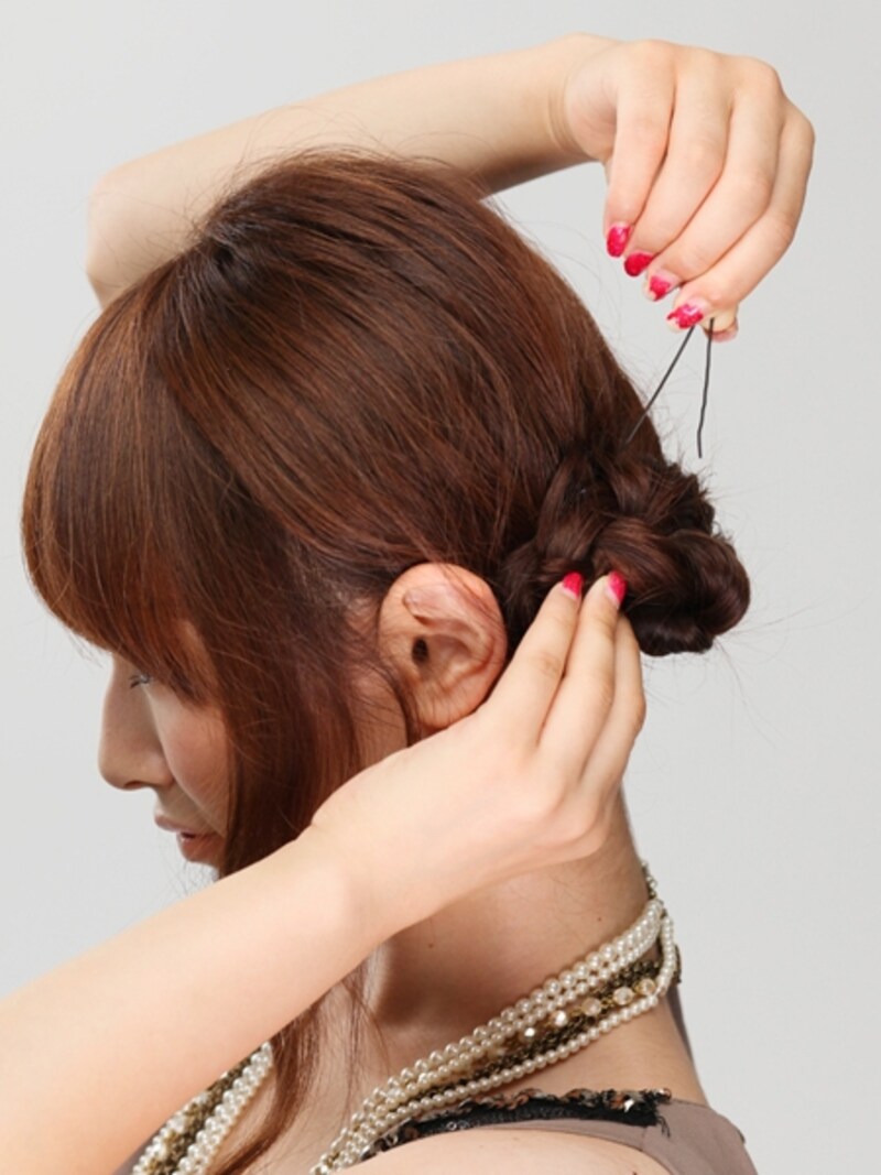 おだんごになったみつあみを4～5カ所アメピンでとめしっかり固定する