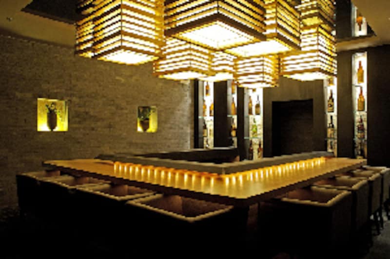 暗い店内にぼんやり浮かび上がる石や木の素材感が、居心地のよさを演出する。