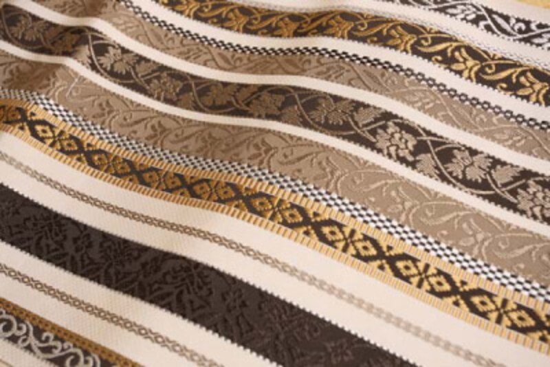 男性の手織り職人による帯。色・柄だけでなく、太い経糸(よこいと)を力強く打ち込むことによって、ハリとコシの強い、男性的な帯になります。撮影:太田耕二