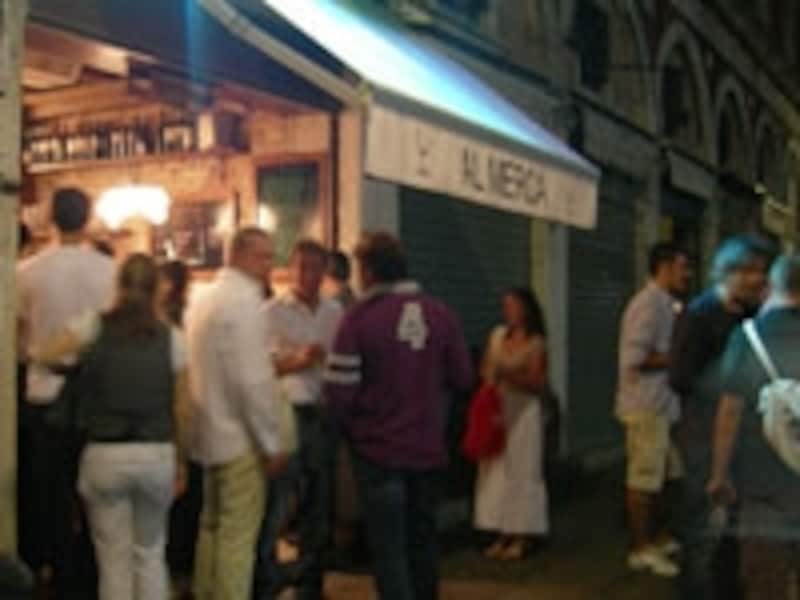 店の外でワイン片手に賑わう人々