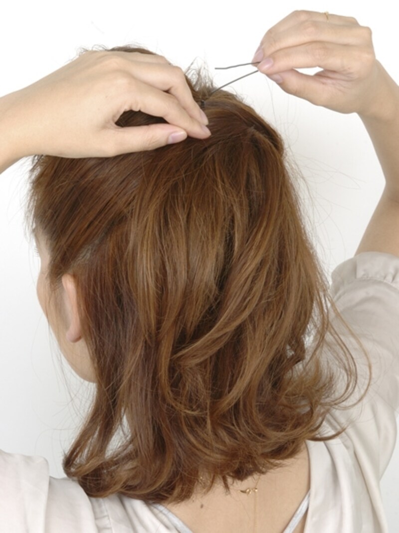 頭皮の毛束としっかりからませアメピンでとめる