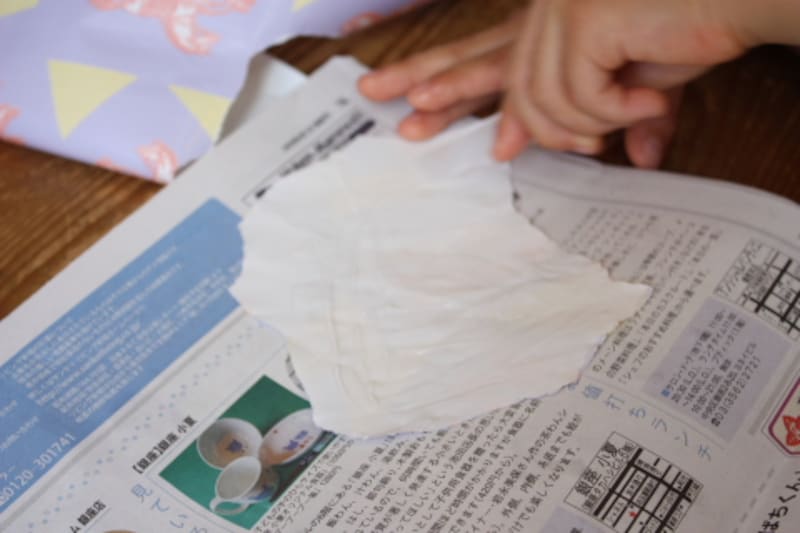 包装紙を好きな形に指で小さく破り、裏にのりをつけます。新聞紙を敷いてのりを塗ると床や机の汚れ防止になります。