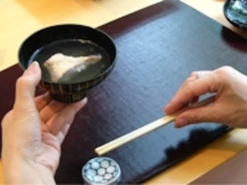 右手で箸を持ち上げる