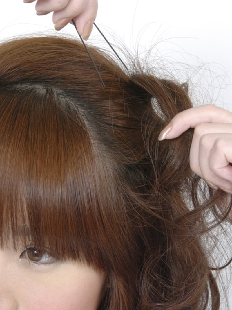 uピンで毛束の上部からふんわり見せるように固定する。