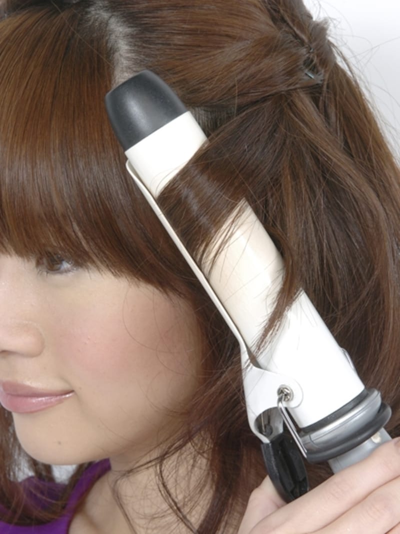 少なめに毛束をとり、32mmのアイロンで毛先から巻きこむ。