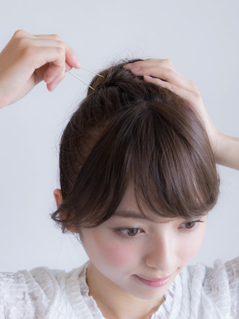 頭皮に垂直にピンをあててから毛束とベースの髪を両方合わせて留めていく