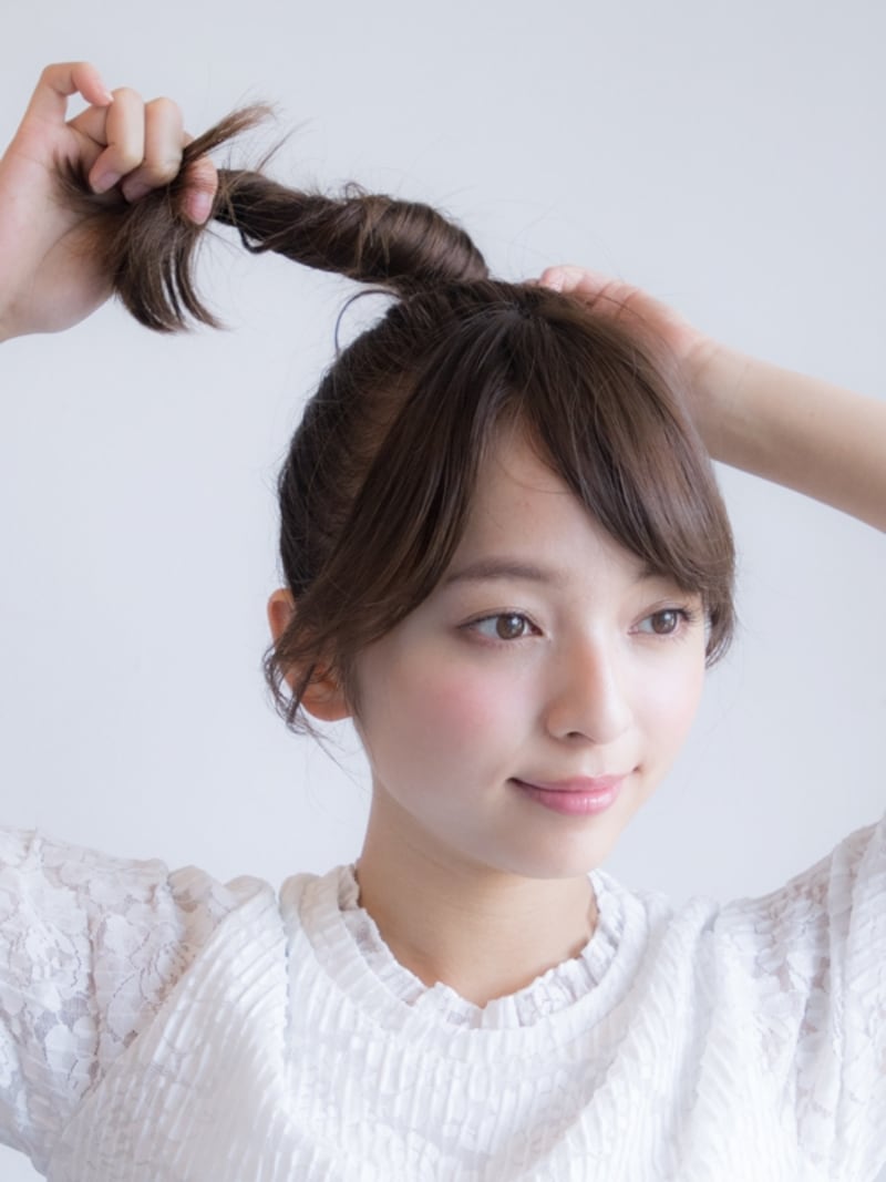 ポニーテールの毛先を持ち、毛束をねじり上げる