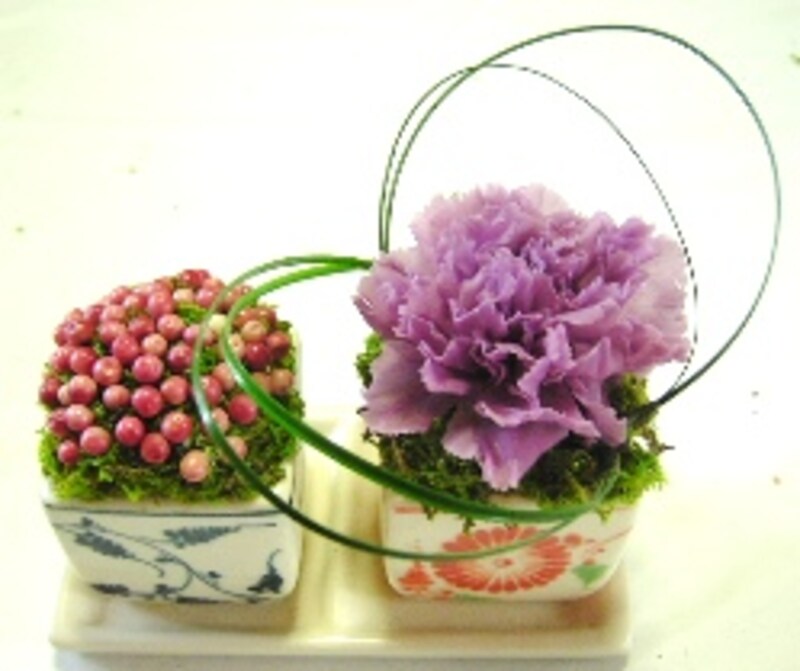 花器の真ん中にカーネーションを深く挿し、ベアグラスを挿します