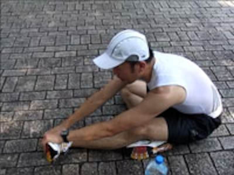 右足を折りその上に左脚を伸ばし、立てた足の爪先を前屈しつつ手前に引く。続いて爪先を外側へ倒して抑え（写真の状態）、さらに反対に倒して抑える