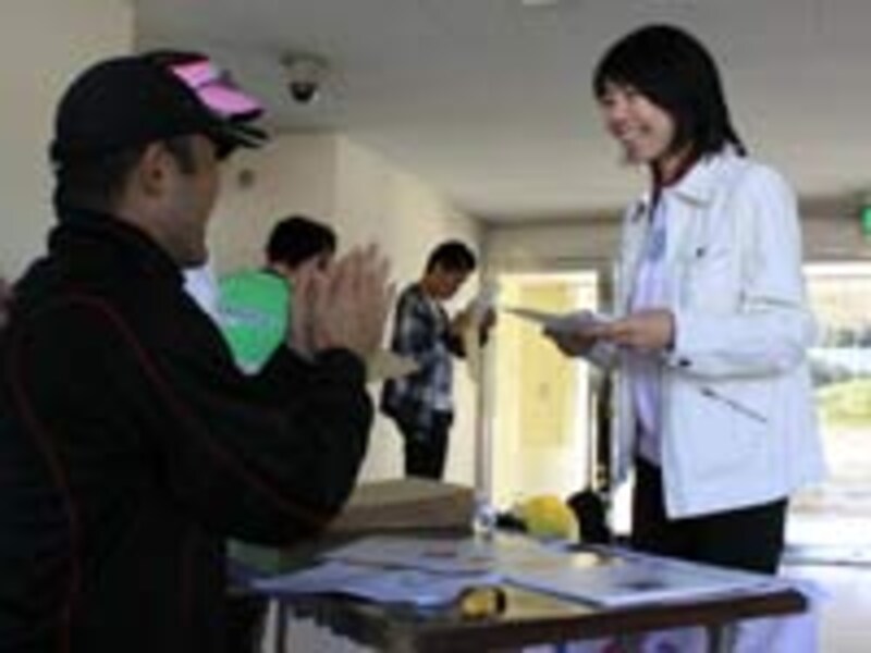 自己記録を更新して笑み満面。金哲彦氏から祝福を受ける