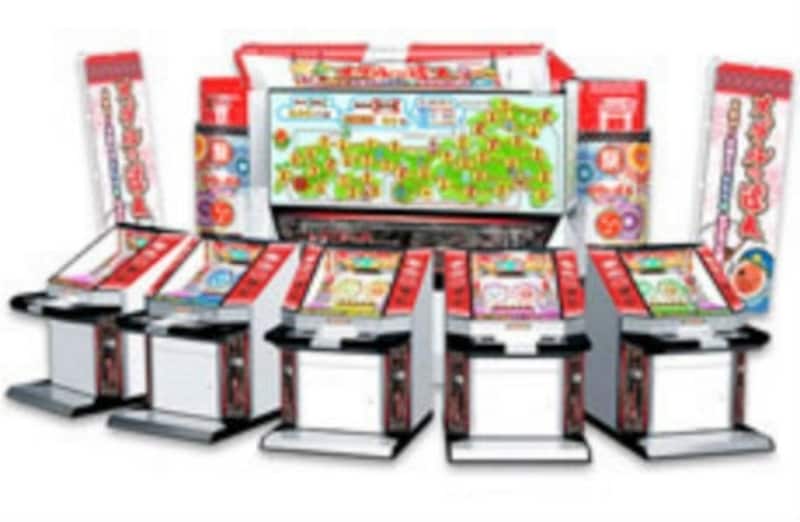 「メダルの達人」のゲーム本体。各シート前にすごろく盤面を表示するプロジェクターが立つ (C)NBGI