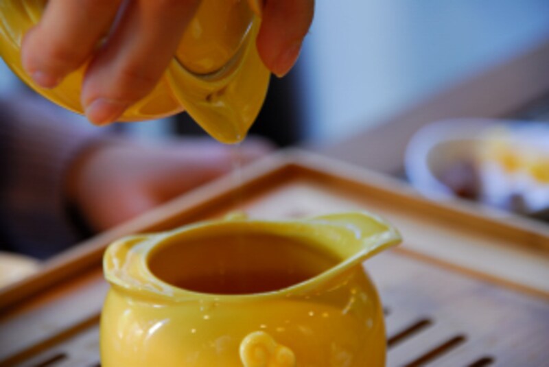 黄色い茶器で茶を淹れる画像