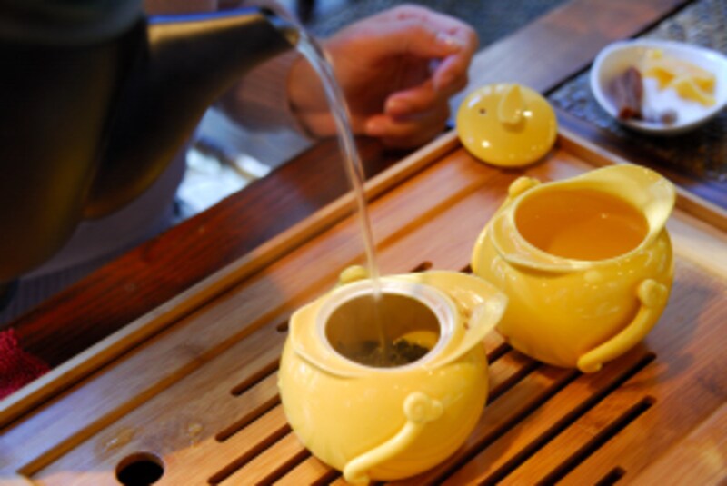 黄色い茶器に湯を注ぐ画像