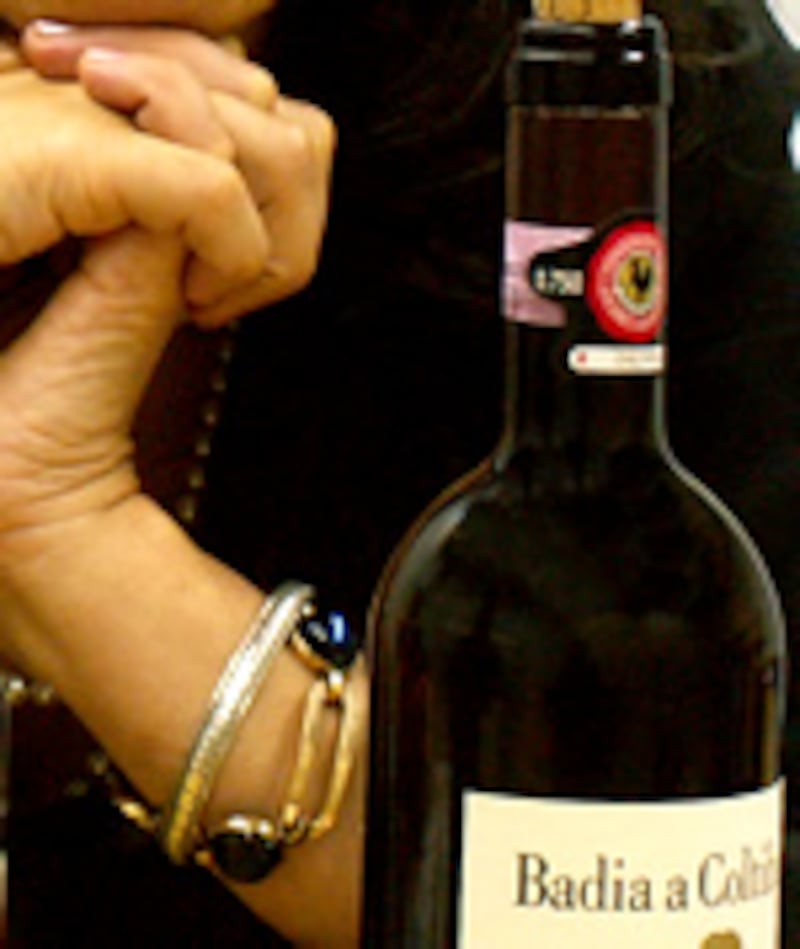 ブレスレットをした手を組み、ほおづえをつく様子